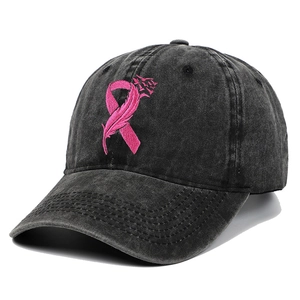 Detailed embroidery of a pink breast cancer ribbon and feather on a black cotton baseball cap