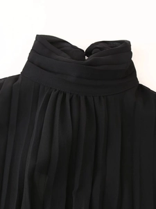 Detail of black chiffon dress featuring a pleated stand collar and ruffled neckline texture