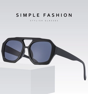 Detail of black frame sunglasses with dark grey lenses on a white geometric stand