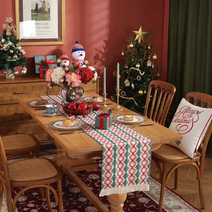 Christmas table runner with red and green geometric patterns and tassel fringe decor