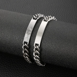 Close-up of silver stainless steel Cuban link bracelet with brushed metal plate on leather
