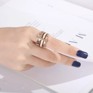 Detailed shot of triple-layer rose gold Roman numeral ring with micro-pave crystals