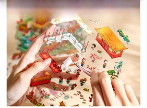 Detail of using tweezers to peel Chinese style palace stickers for journaling DIY