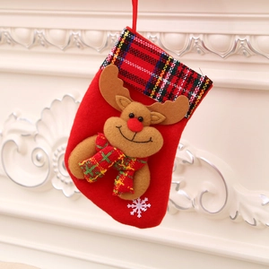 Red felt Christmas stocking with reindeer plush hanging on an elegant white fireplace