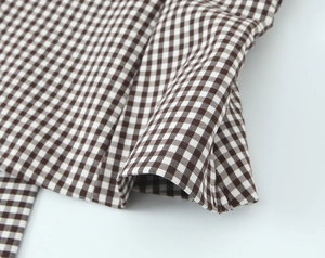 Detailed close-up of brown and white checkered fabric texture with soft folded layers