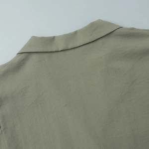 Detail of olive green shirt collar and shoulder with breathable linen fabric texture