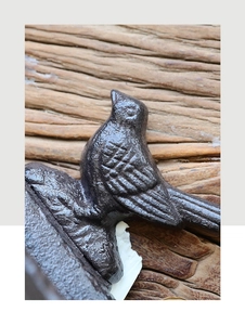 Macro shot of a vintage cast iron bird figurine with textured rustic brown metal finish