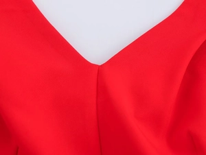 Detailed close-up of the V-neck design and smooth red fabric texture on a women's dress