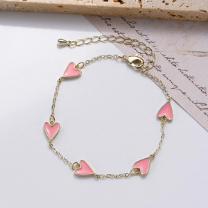 Detail of gold heart bracelet with five pink enamel pendants and adjustable lobster clasp