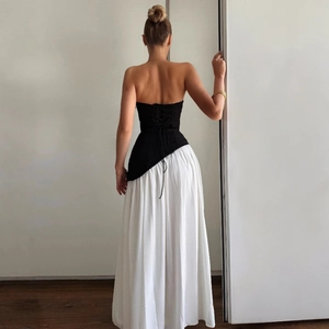 Detail view of monochrome two-piece set featuring lace-up back top and white pleated skirt