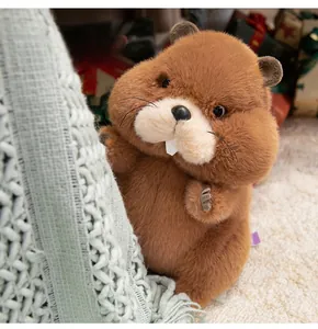 Close-up of a cute brown marmot plush toy with soft fur and white teeth in a cozy room