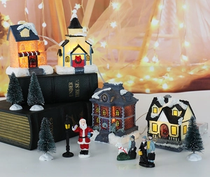 Details von beleuchteten Weihnachtshäusern aus Harz mit warmen LEDs und Miniaturfiguren