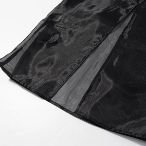 Détail du tissu en organza noir avec appliques florales 3D et coutures verticales