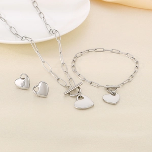 Silver jewelry set with heart pendants including paperclip chain necklace, bracelet, and studs