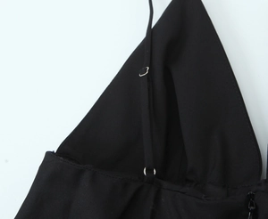Close-up of adjustable thin shoulder straps and silver metal buckles on black dress