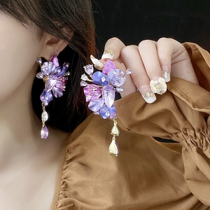 Detailed view of floral drop earrings with purple crystals and water drop pendants