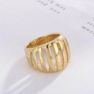 Detail shot of golden wide hollow stripe ring with polished metallic finish on white paper