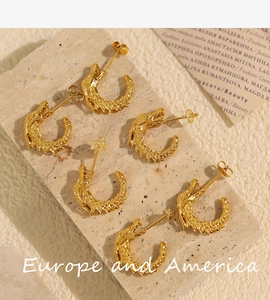 Macro detail of golden dragon C-shape earrings showing intricate scale textures and relief