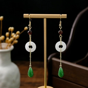 Detail of vintage long tassel earrings with white donut bead and green teardrop pendant