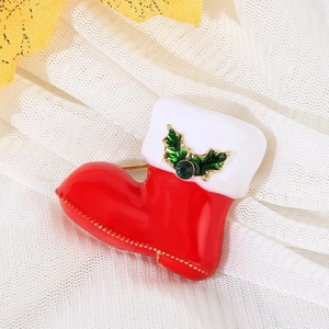Detail of red enamel Christmas boot brooch with green holly leaves and crystal accent