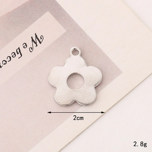 Detail view of a 2cm silver flower pendant showing its 2.8g weight and polished metal finish