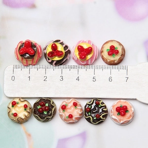 Detailed view of assorted 2cm miniature resin cakes and desserts with a scale ruler