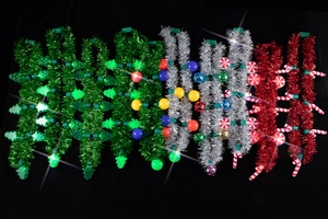 Close-up of festive Christmas tinsel necklaces with colorful ornaments and LED lights