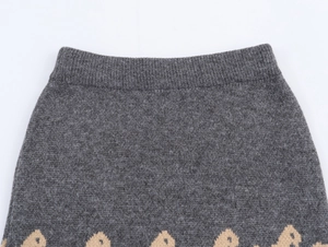 Macro detail of dark grey knit fabric with yellow jacquard patterns and texture