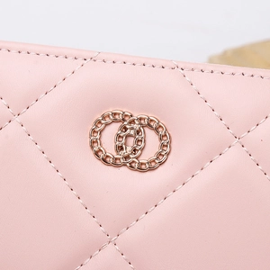 Macro shot of pink quilted leather texture with rose gold interlocking chain detail