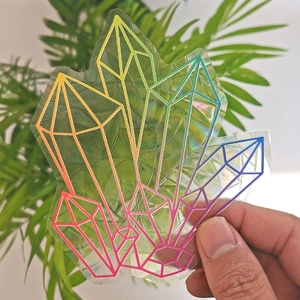 Detail of geometric suncatcher sticker with holographic rainbow prism effect on glass