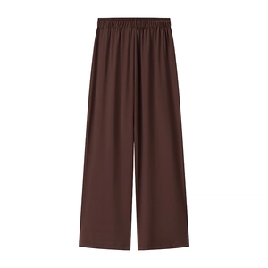 Dettaglio di pantaloni in maglia marroni a gamba larga con vita elastica e drappeggio