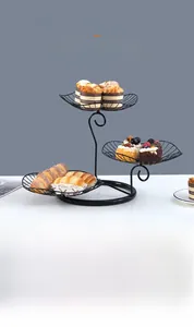 Close-up of three-tier black metal fruit basket with elegant leaf-shaped wire design