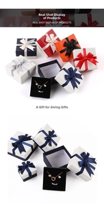 Square jewelry boxes with ribbon bows and velvet inserts in navy, red, orange, and white
