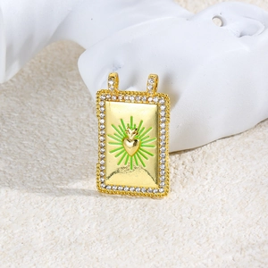 Detail of a vintage gold-plated heart pendant with green enamel and crystal inlay