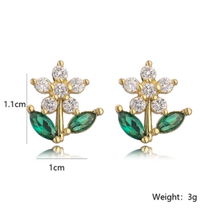 Gold flower earrings with white zircon center and green leaf stones on white background