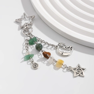 Celestial silver keychain with star, moon, and turquoise beads on a white marble display