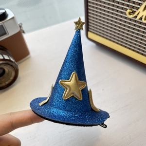 Détail d'une pince à cheveux chapeau de sorcier à paillettes bleues avec étoiles dorées