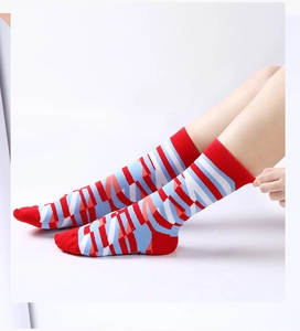 Detail der elastischen Bündchen an geometrisch gestreiften Socken in Rot und Blau