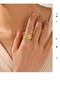 Detail shot of a wide gold hammered texture ring on a model in a minimalist style