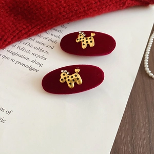 Close-up of velvet oval hair clips featuring golden poodle motifs with sparkling rhinestones