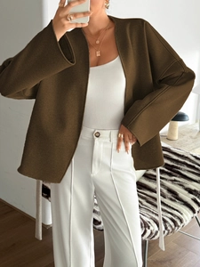 Detail of a brown wool-like cardigan jacket with ties and long sleeves in a home setting
