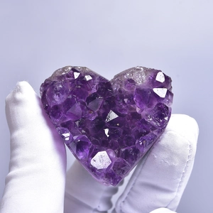Natural heart-shaped Uruguay amethyst cluster geode specimen held in hand