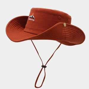 Detail of rust red outdoor hat featuring Wildcamp embroidery and adjustable windproof cord