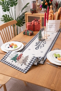 Christmas table runner with festive trees and Merry Christmas text on rustic wood