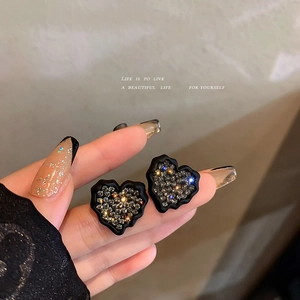 Boucles d'oreilles cœur élégantes avec bordure noire ondulée et strass gris tenues à la main