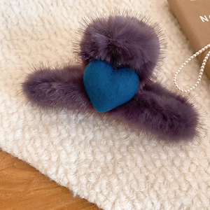 Detail view of plush autumn hair claw clip with purple faux fur and blue heart decoration