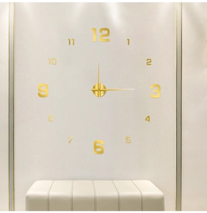 Detail of DIY golden acrylic wall clock with luminous numbers on a clean white wall