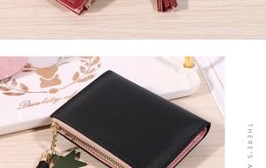 Close-up of black PU leather bifold wallet with tassel zipper and green star charm detail