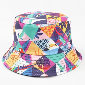 Détail d'un chapeau bob réversible coloré avec motifs de forêt tropicale et de perroquets