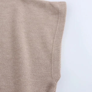 Detailed close-up showing the soft beige knitted fabric texture and precise stitching detail
